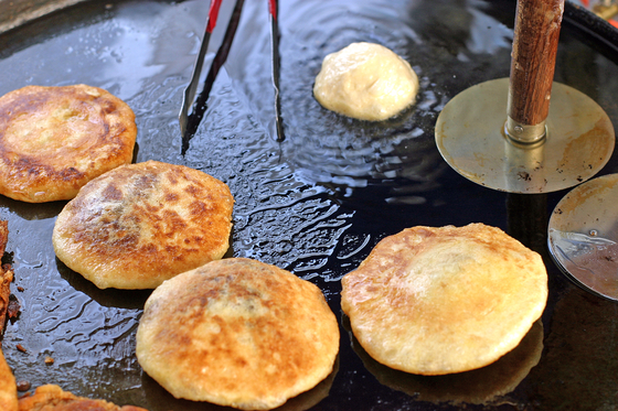 Hotteok is a flat circular bread filled with sugar, and often nuts and seeds as well [JOONGANG ILBO]