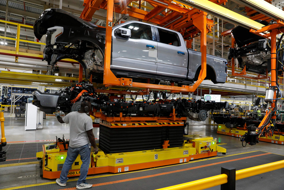 F-150 Lightning trucks under production at Ford's plant in Dearborn, Michigan. The automaker suspended the production after its battery, made by SK On, caught fire. [AFP/YONHAP]  