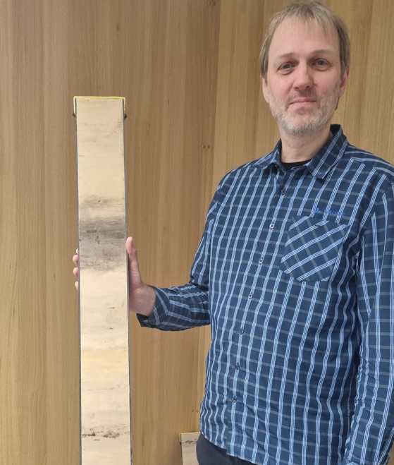 Matthias Forwick holds up a mock-up of sediment core, a cylindrical sample drilled from the sea floor, at the Arctic University of Norway in Tromso on Feb. 2. [SHIN HA-NEE]