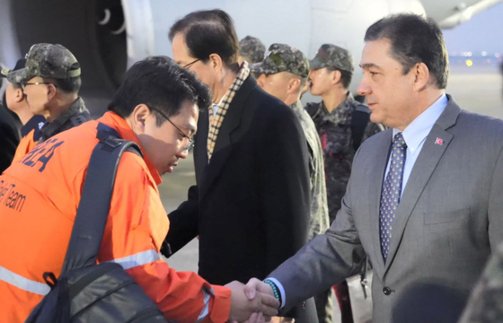 Turkish Ambassador to Seoul Murat Tamer, right, greets Korean rescue workers returning from Turkey at Seoul Air Base in Seongnam, Gyeonggi, on Saturday. [FOREIGN MINISTRY]