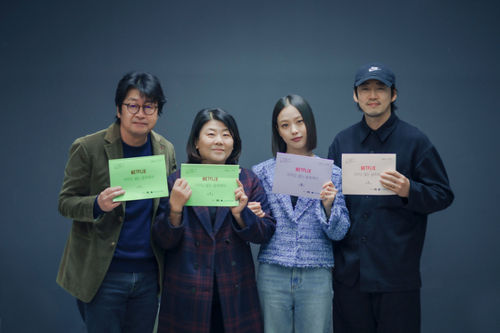 The cast of the Netflix series “In the Woods Where There's No One” (translated)″ pose for a photo with their scripts. From left, actor Kim Yoon-sik, Lee Jung-eun, Go Min-si and Yoon Kye-sang [NETFLIX]