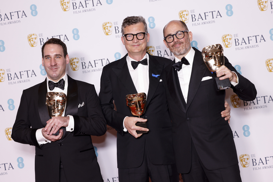 From left, James Friend, winner of the cinematography award, Malte Grunert and Edward Berger winners of the Best Film Not in the English Language award for ″All Quiet on the Western Front,″ pose for photographers at the 76th British Academy Film Awards, BAFTA's, in London, Sunday local time. [AP]