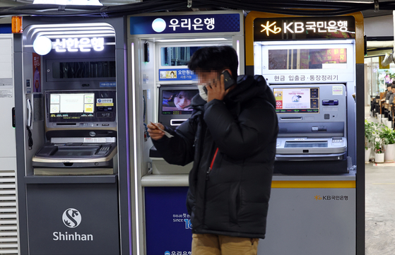 A customer walks past ATMs in Seoul on Feb. 16. [YONHAP]