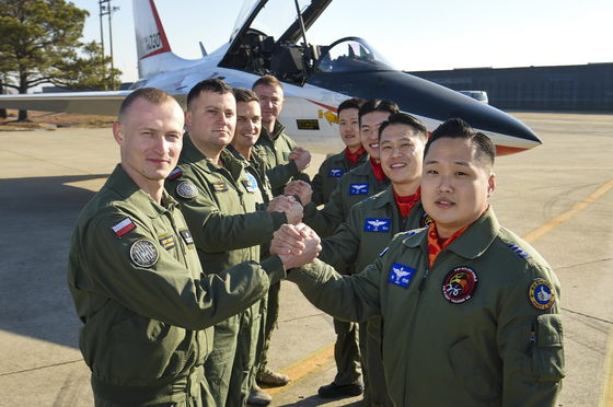 Korean and Polish air force pilots pose in front of a T-50 trainer aircraft at Korea's 1st Fighter Wing in Gwangju, 329 kilometers south of Seoul, as the Polish service members begin their training to operate the FA-50 aircraft. Currently, four countries — Indonesia, Iraq, the Philippines and Thailand — operate the T-50 series aircraft. The Korean Air Force has trained 47 pilots from the four countries since 2013 and continues to provide the countries with follow-up logistics support. [KOREA AIR FORCE] 