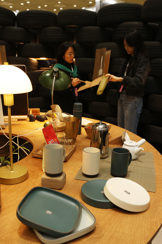 Visitors to the Seoul Living Design Fair 2023 take a look at products and booths made out of leftover wood materials from construction sites and waste tires. Participating companies in the design fair will exhibit furniture, interior design efforts and construction products at COEX in southern Seoul until Friday. [YONHAP] 