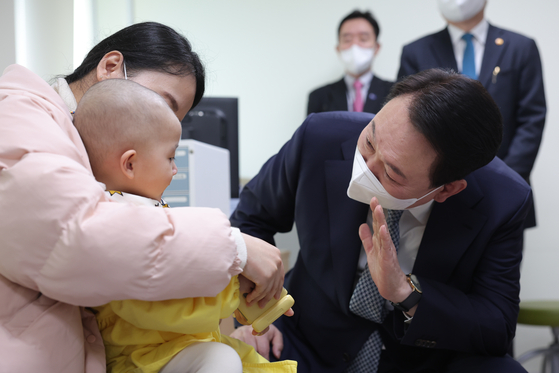 President Yoon Suk Yeol meets a 19-months old patient at Seoul National University Hospital in Jongno, Seoul, on Wednesday. [YONHAP]