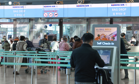A passenger stands in front of Korean Air's self check-in kiosk at Incheon International Airport on Monday afternoon. [YONHAP]