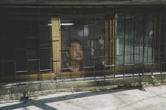 Actor Song Kang-ho looks out the window of banjiha, or a semi-basement apartment, in the Oscar-winning film ″Parasite.″ [CJ ENM]