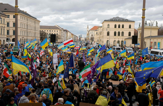 Demonstrators wave flags of Ukraine, Iran, Europe, Georgia, Lithuania and others as they take part in a pro-Ukrainian rally at Odeonsplatz square on the sidelines of the Munich Security Conference in Munich, Germany, on Feb.18. [AFP/YONHAP]