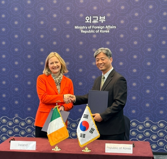 Sonja Hyland, deputy secretary general at Department of Foreign Affairs of Ireland, left, and Choi Young-han, director-general for overseas Koreans and consular affairs at the Foreign Ministry, sign an agreement to increase the age limit for their working holiday programs in Seoul on Thursday. [MINISTRY OF FOREIGN AFFAIRS]