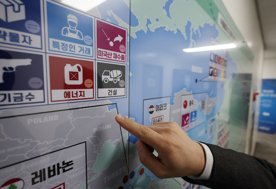 A trade official points to Belarus on a status board designating Korea's restrictions on exports of strategic items at the Korean Security Agency of Trade and Industry in Seoul on March 7, 2022. [YONHAP]