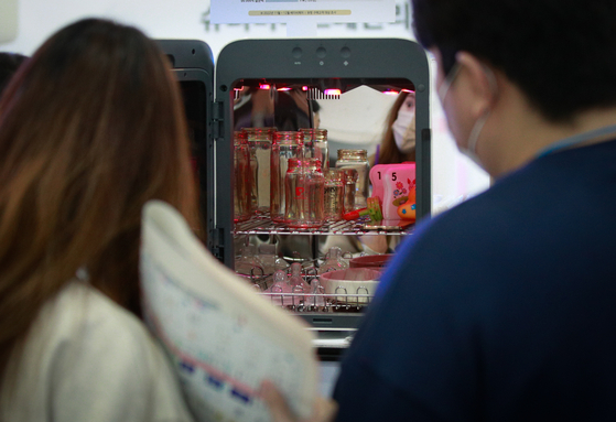 People look at a baby bottle sterilizer while visiting a baby product fair held at COEX, southern Seoul, on Feb. 9 [NEWS1]