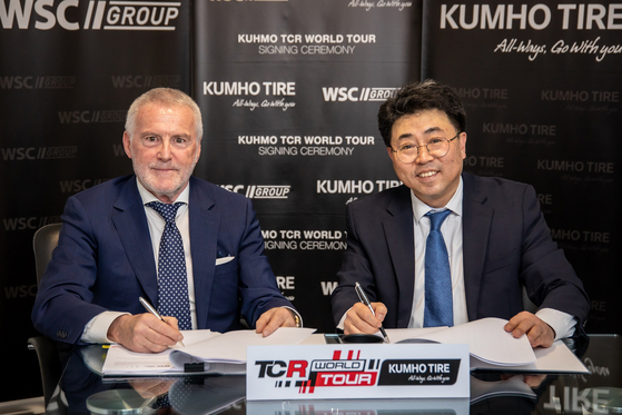 WSC Group President Marcello Lotti, left, and Yoon Jang-hyuk, managing director of global marketing at Kumho Tire, sign a sponsorship deal for the Kumho Touring Car Racing World Tour in Lugano, Switzerland, on Thursday. [KUMHO TIRE]