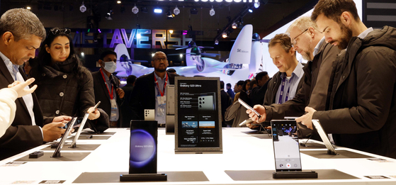 Visitors try out Samsung Electronics’ Galaxy S23 Ultra at MWC 2023 at the company’s booth on Tuesday. The MWC, or Mobile World Congress, runs until Thursday in Barcelona, Spain. [YONHAP]