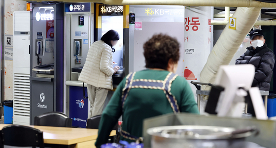 A customer uses an ATM installed in front of a diner in Seoul on Feb. 16. [YONHAP]