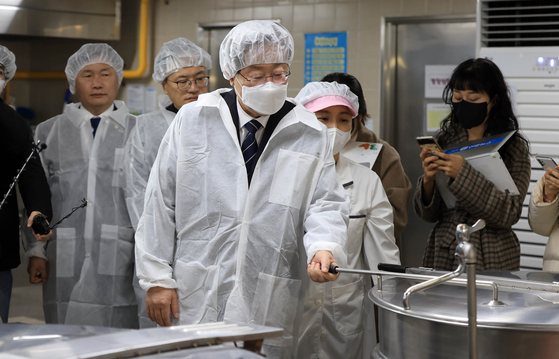 Democratic Party leader Lee Jae-myung in a kitchen at an elementary school in Eunpyeong District, in Seoul on Tuesday. [YONHAP]