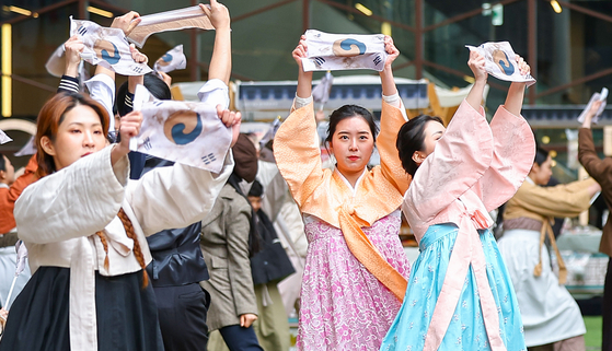 Musical drama students at Hongik University perform a recreation of the March 1 Independence movement in Insa-dong, Seoul, on Tuesday, just a day before the 104th anniversary. According to the presidential office, President Yoon Suk Yeol plans to emphasize freedom, dedication, past memories, the future and prosperity during his speech on Wednesday. [YONHAP] 