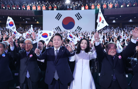 President Yoon Suk Yeol and first lady Kim Keon Hee, center, wave the Taegukgi during a ceremony marking the 104th anniversary of the March 1 Independence Movement at the Memorial Hall of Yu Gwan-sun in central Seoul Wednesday. [JOINT PRESS CORPS]