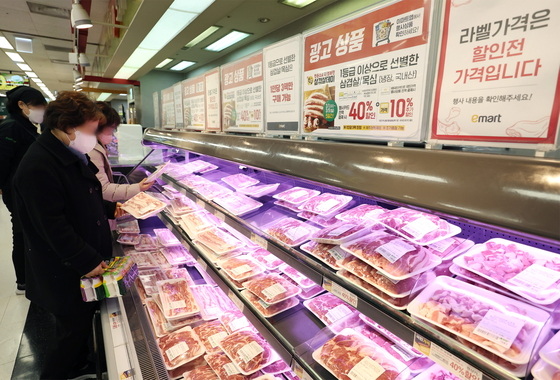 A customer shops for packs of samgyeopsal, or pork belly, at Emart's Yongsan branch in central Seoul, on Wednesday. Discount marts are running promotions on pork belly ahead of March 3, popularly known in Korea as Samgyeopsal Day. [YONHAP]