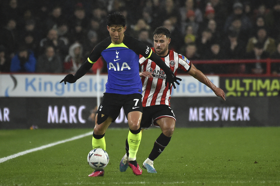 Tottenham's Son Heung-min, left, and Sheffield United's George Baldock fight for the ball during an FA Cup fifth round match at Bramall Lane in Sheffield, England on Wednesday.  [AP/YONHAP]