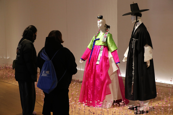 Visitors look at hanbok, or Korean traditional dress, at the ″Traditional Hanbok, Lifetime Ceremony″ (translated) exhibition at the Ara Art Center in central Seoul on Jan. 27. The exhibition was hosted by the Korea Craft and Design Foundation and ended Jan. 29. [NEWS1]