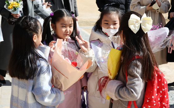 First grade students greet and talk with their friends during a commencement ceremony at Gangbit Elementary School in Gangdong District, eastern Seoul, Thursday morning. Thursday's event was the school's first commencement ceremony held face-to-face in about four years due to the Covid-19 pandemic. [YONHAP]