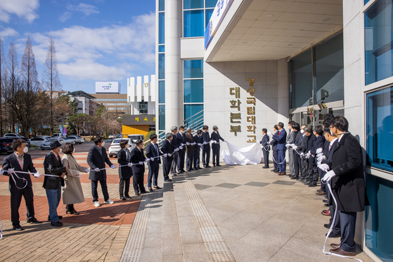 School officials at Gyeongsang National University unveil new block letters of the university’s headquarters on Chilam Campus in Jinju, South Gyeongsang, on March 2, 2021, after the school merged with Gyeongsang National University of Science and Technology [GYEONGSANG NATIONAL UNIVERSITY]