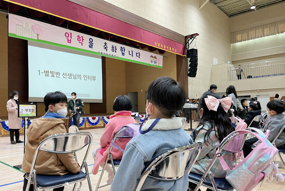 First grade students attend a commencement ceremony with their masks on at an auditorium in Gangbit Elementary School in Gangdong District, eastern Seoul, Thursday. [NEWS1] 