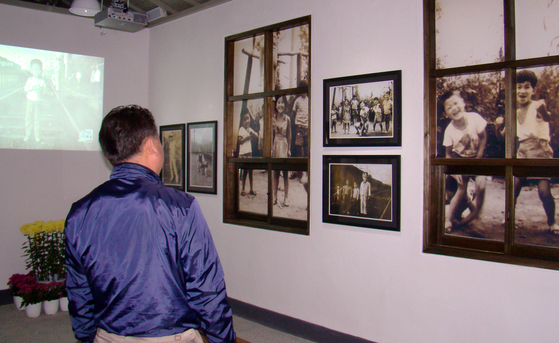 A man examines the black-and-white photos hung up on the walls of Neungnae Station's waiting area. [YONHAP]