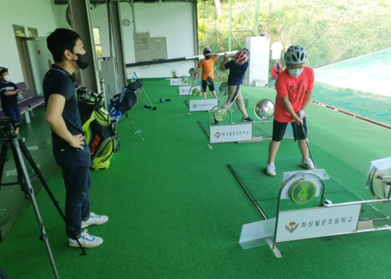 Students at Hwaseong Wolmun Elementary School in Hwaseong, Gyeonggi, are learning golf during gym class. The school established its own golf facilities in order to differentiate itself from other schools in the region and attract more students. The school’s golf program has helped Hwaseong Wolmun Elementary School to stay open amid a declining number of students in Hwaseong city due to the aging society. [HWASEONG WOLMUN ELEMENTARY SCHOOL]