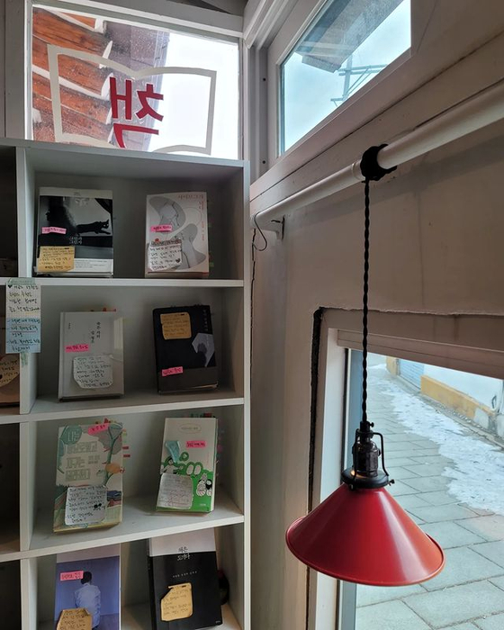 Post-its with a short book review written by the owner are stuck on each book at Seochon Books. [SEOCHON BOOKS]