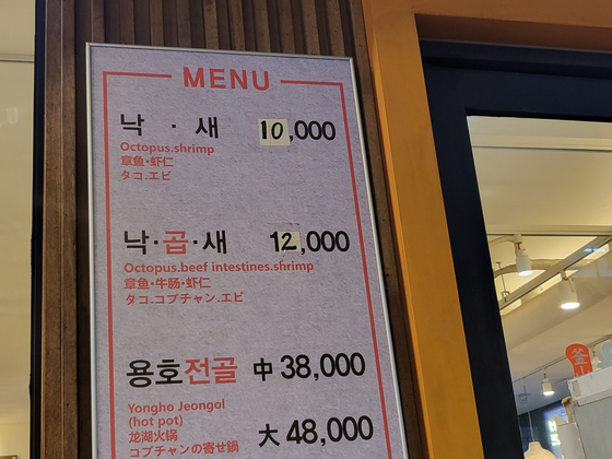 Tapes on a menu board at a restaurant in Seoul shows the changed meal prices. [SEO JI-WON]