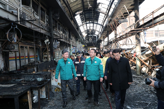 Vice Minister of the Interior and Safety Han Chang-seob, left, and Incheon Mayor Yoo Jeong-bok inspect the charred ruins of Hyundae Market in Dong District, Incheon on Sunday. [YONHAP]