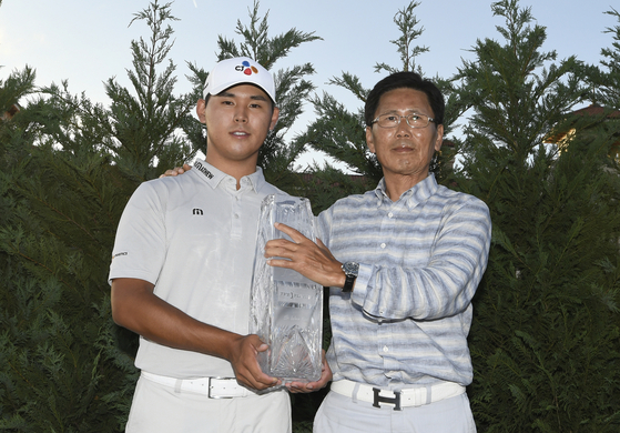 Kim Si-woo poses with his father and The Championship trophy during the final round of The Players Championship at TPC Sawgrass in Ponte Vedra Beach in Florida on May 14, 2017.  [GETTY IMAGES]
