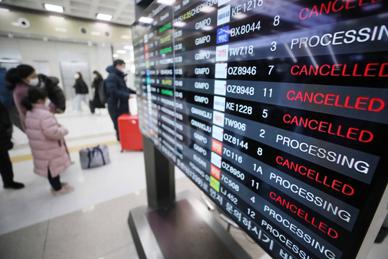 An electronic display board shows flights in and out of Jeju Island get cancelled on Jan. 27 due to harsh weather conditions. [YONHAP] 