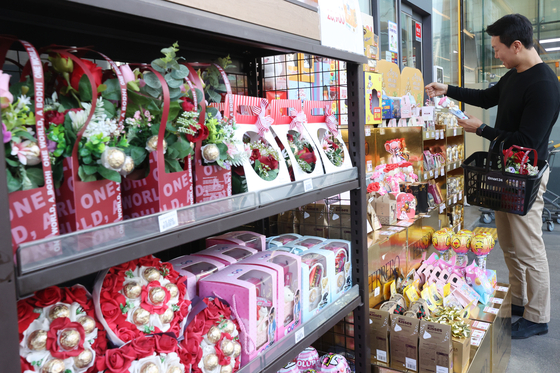 A customer shops for ″White Day″ gifts at a convenience store in Seoul on Monday. White Day, March 14, is a version of Valentines Day in Korea where people exchange candy with their loved ones. [YONHAP]