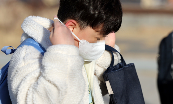An elementary school student wears a mask on the way to school on Thursday. [YONHAP]
