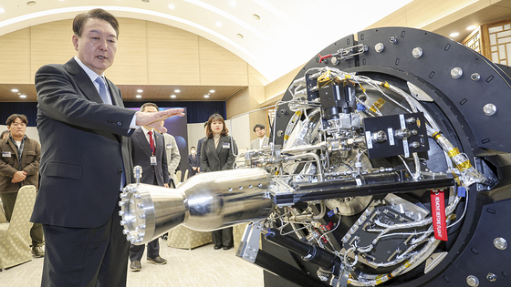 President Yoon Suk Yeol looks at a small-scale space launch vehicle during a meeting with researchers, investors, students and businesspeople in the space sector at the presidential office in Yongsan District, central Seoul, on Feb. 21. [YONHAP]