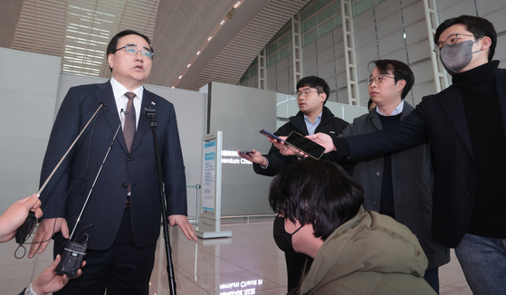 National Security Adviser Kim Sung-han, left, speaks to reporters at Incheon International Airport on Sunday, ahead of a five-day visit to Washington. [YONHAP]