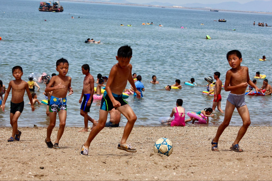 Children play football in North Korea in an image from Lindsey Miller's book "North Korea: Like Nowhere Else."  [LINDSEY MILLER]