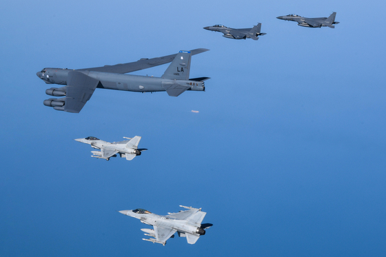 A U.S. B-52 Stratofortress long-range bomber flies at the front of a formation with South Korean KF-15 Slam Eagle strike fighters (above) and F-16K Fighting Falcon fighters (below) in the skies above the West Sea on Monday. [DEFENSE MINISTRY]