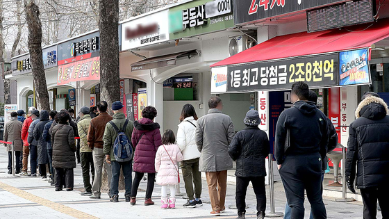 People stand in a queue to buy lottery tickets in Seoul before the Lunar New Year holiday. [NEWS1]