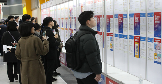 Job seekers look through job postings on a bulletin board at a job fair in Seocho District, southern Seoul, on March 2. [NEWS1]