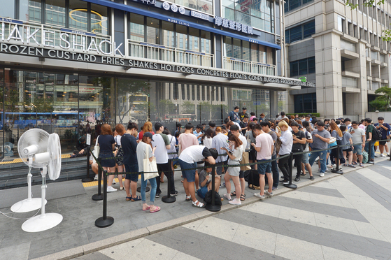People wait in line to receive 100 free burgers from Shake Shack’s Gangnam branch in August 2016 as the brand celebrates 100 branches in operation worldwide. [JOONGANG ILBO]
