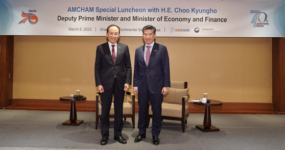 Finance Minister Choo Kyung-ho, left, and James Kim, CEO and chairman of the American Chamber of Commerce in Korea (Amcham), pose for a photo at a conference held in southern Seoul on Wednesday to discuss economic policy. [AMCHAM]