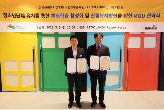 Legoland Korea Resort Marketing Director Lee Jeong-il, left, poses for a photo with Chuncheon National Center for Forest Education Director Choi Jeong-ho at a MOU-signing ceremony held at the global theme park in Chuncheon, Gangwon, on Thursday. [LEGOLAND KOREA RESORT]