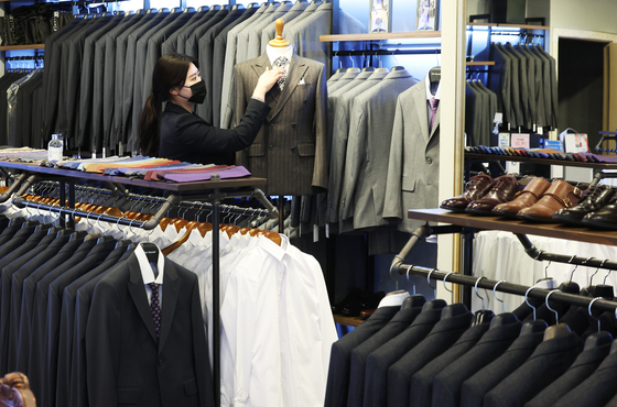 An employee organizes displayed suits at a suit shop in Yeongtong District, eastern Suwon, on Thursday afternoon. The city government of Suwon has been running a free suit rental program ″Chungnarae″ for Suwon residents between the ages of 19 and 34 who are preparing for job interviews since March 2. [YONHAP]