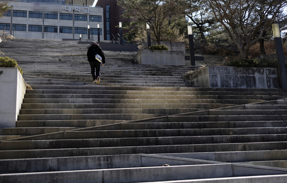A student walks up an empty staircase on a university campus in North Gyeongsang. [YONHAP]
