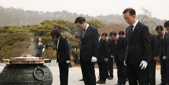 The People Power Party's new leader Kim Gi-hyeon, center, pays respects at Seoul National Cemetery in Dongjak District, southern Seoul, on Thursday. It was his first official event as party chief. The four-term lawmaker won the PPP leadership race Wednesday with 53 percent of the vote. His closest challenger, Ahn Cheol-soo, received 23.37 percent. [YONHAP]