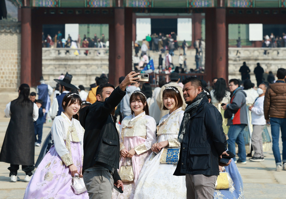 Tourists pose for pictures at Gyeongbok Palace in central Seoul on March 5. [YONHAP] 